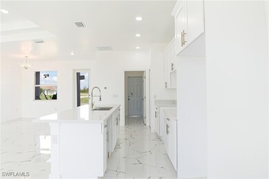 Kitchen with white cabinetry, a notable chandelier