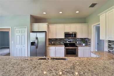 KITCHEN FEATURING GLASS TILE BACK SPLASH AND STAIN