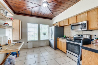 Kitchen with ceiling fan, light tile floors, backs