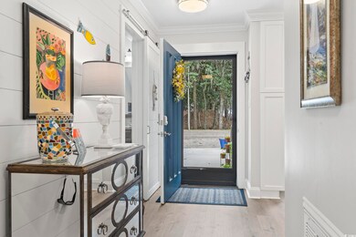 Foyer with crown molding and light wood-style floo