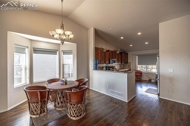 Dining area with an inviting chandelier, dark hard