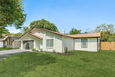 Ranch-style home featuring a garage and a front ya