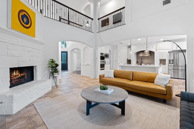 Living room featuring arched walkways, a stone fi