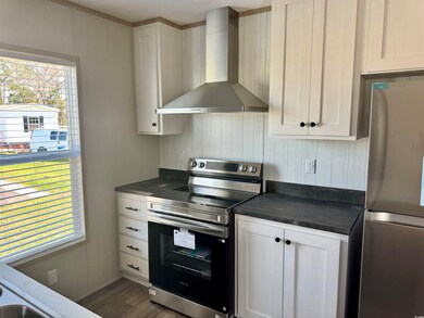 Kitchen featuring dark wood-style floors, white ca