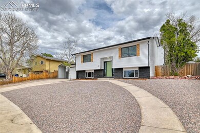 Raised ranch with driveway, fence, and brick sidin