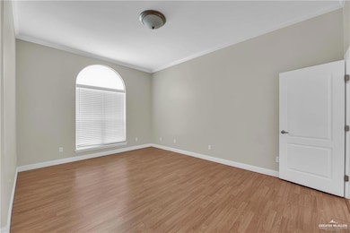 Unfurnished room featuring ornamental molding and light wood-style flooring