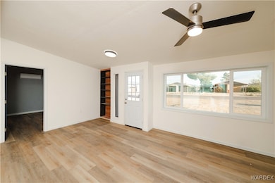 Empty room featuring a wall unit AC, a ceiling fan