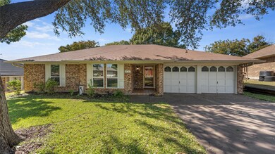 Ranch-style home featuring concrete driveway, a front yard, brick siding, and an attached garage