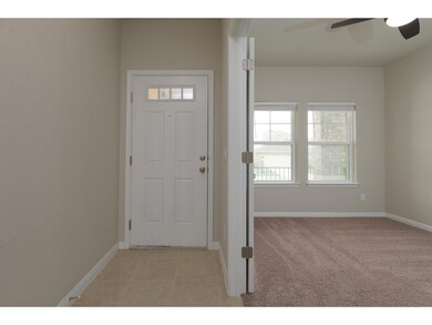 Foyer entrance with ceiling fan, baseboards, and 