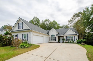 View of front of house featuring a shingled roof, driveway, a front yard, and an attached garage