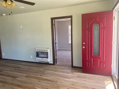 Entryway with ceiling fan, heating unit, and wood finished floors