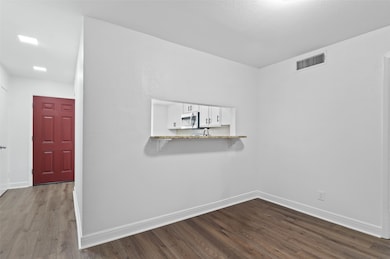 Living area with new flooring and paint featuring a pass-through window to the kitchen.