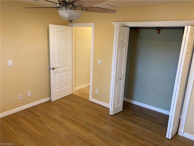 Unfurnished bedroom with baseboards, dark wood finished floors, a closet, and a ceiling fan