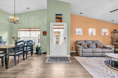 Living room featuring lofted ceiling, ceiling fan 