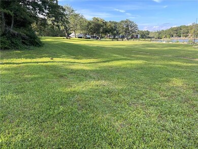 View of community featuring a yard, view of wooded area, and a water view