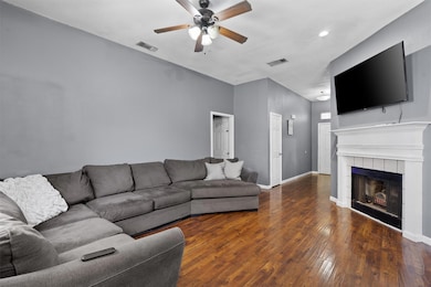 Living room featuring ceiling fan, hardwood / woo
