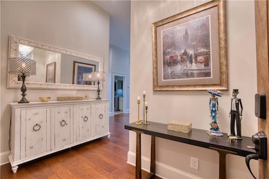 Foyer with dark wood-style floors and baseboards