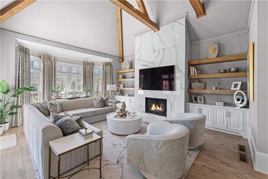 Living area with light wood-style floors, beam cei