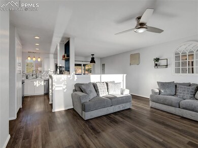Living room with ceiling fan and dark hardwood / w
