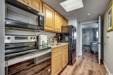 Kitchen with light countertops, light wood-style f