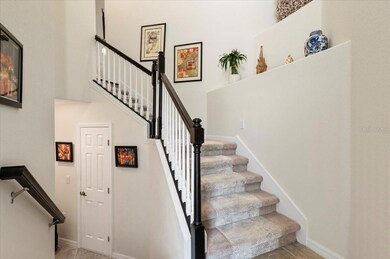 View from the foyer at the front door; to the left is the entrance from the garage (door not shown); door on the right leads to the hidden storage area; notice the custom stained bannister and carpet runners.