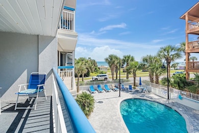 Community pool featuring a balcony, a patio area, and a water view
