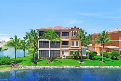 Back of house with a balcony, a lawn, and a water 