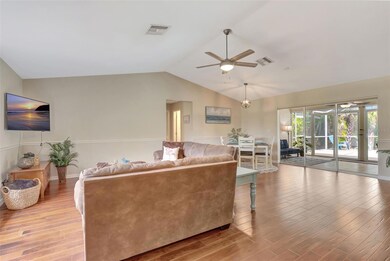 Step into a light-filled great room with vaulted ceilings, Acacia engineered hardwood floors, and a wall of sliders leading to the Florida room.