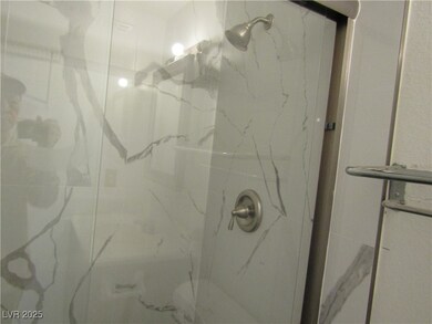Bathroom featuring a marble finish shower