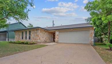 View of front of property with stone siding, driv