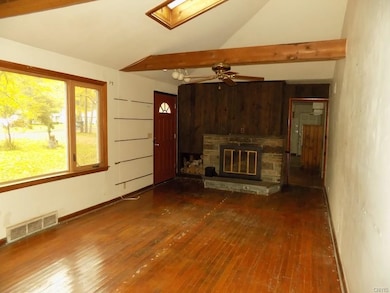 Hardwood floors, wood beams, and a skylight in the