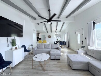 Living area featuring wood finished floors, healthy amount of natural light, and a ceiling fan