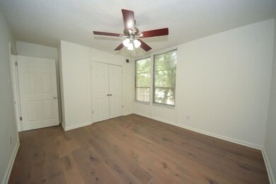 Unfurnished bedroom with wood finished floors, a closet, and a ceiling fan