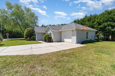 View of front of house with an attached garage, a shingled roof, driveway, and a front lawn