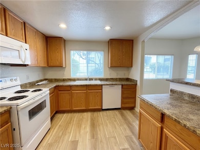 Kitchen with white appliances, a sink, plenty of n