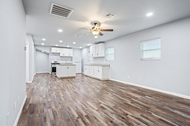 Unfurnished living room featuring dark wood-type 