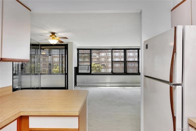 Kitchen with freestanding refrigerator, carpet, a ceiling fan, baseboard heating, and cooling unit