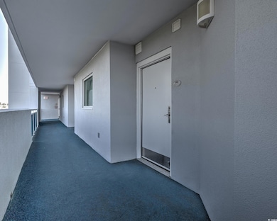 View of exterior entry with stucco siding and a balcony
