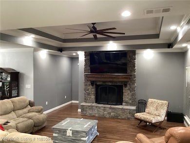 open family room, stone fireplace, wood floors.
