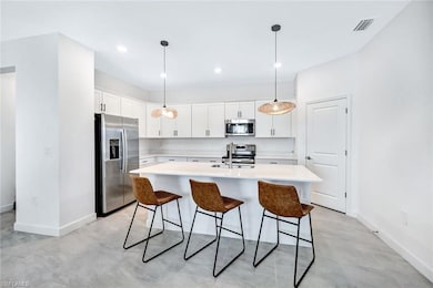 Stainless appliances, large island, and pantry wit