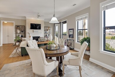 Dining room with a fireplace, ceiling fan, ornamental molding, and light wood finished floors