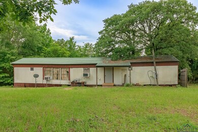 Back of property with a lawn, metal roof, and cooling unit