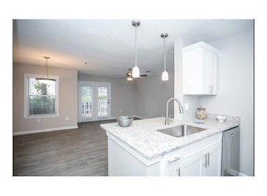 Kitchen featuring ceiling fan, white cabinets, pen