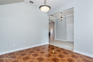 Tiled empty room featuring arched walkways and ornamental molding