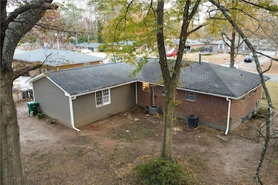 View of home's exterior with a shingled roof and brick siding