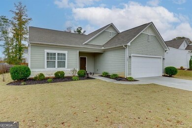 View of front of property featuring a shingled roof, a front yard, driveway, and a garage