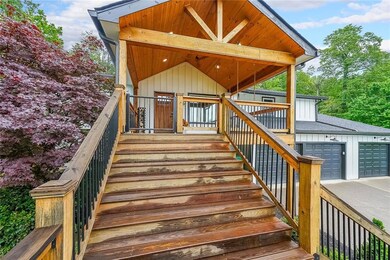Property entrance with an attached garage, concrete driveway, and roof with shingles