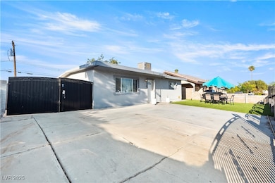 View of front of property featuring a patio, stucco siding, and a gate