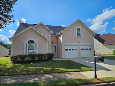 Traditional-style house with stucco siding, a garage, driveway, a front lawn, and a chimney