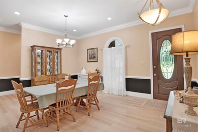 Dining room with a chandelier, ornamental molding, and light wood-type flooring